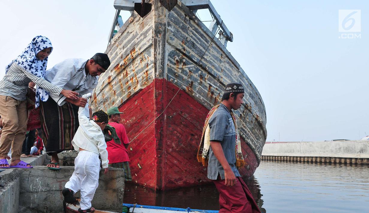  Umat muslim menaiki perahu usai menjalankan Salat Idul Adha 1438 H di kawasan Pelabuhan Sunda Kelapa, Jakarta, Jumat (1/9). Setelah menjalankan salat, umat muslim melakukan penyembelihan hewan kurban. (Liputan6.com/Helmi Afandi)