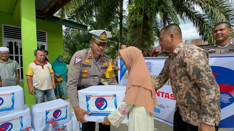 Kasat Lantas Polres Rokan Hulu AKP Tatit Rizkyan Hanafi SIK menyerahkan bantuan sembako kepada warga dalam rangkaian HUT Lalu Lintas Bhayangkara.