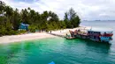 Keindahan pulau ini didukung oleh pepohonan kelapa dan pemandangan laut biru kehijauan yang memukau. Tampak foto udara memperlihatkan perahu nelayan di Pulau Panjang, yang pernah menjadi objek sengketa batas pulau antara Aceh dan Sumatra Utara, di Singkil, Provinsi Aceh bagian selatan, pada Rabu 12 November 2025. (CHAIDEER MAHYUDDIN/AFP)