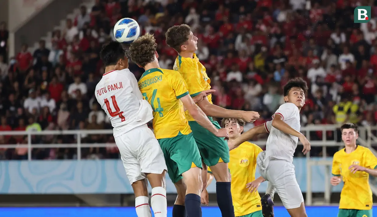 <p>Kapten Timnas Indonesia U-16, Putu Panji (kiri) berduel udara dengan bek Timnas Australia U-16, Alexander Lech Garbowski pada laga semifinal Piala AFF U-16 2024 di Stadion Manahan, Solo, Senin (1/7/2024). (Bola.com/Abdul Aziz)</p>