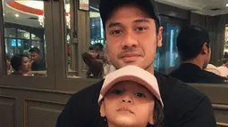Chicco Jerikho dan Surinala kompak memakai topi. Dalam foto ini, ayah dan anak tersebut terlihat sangat mirip. (Foto: Instagram/ chicco.jerikho)