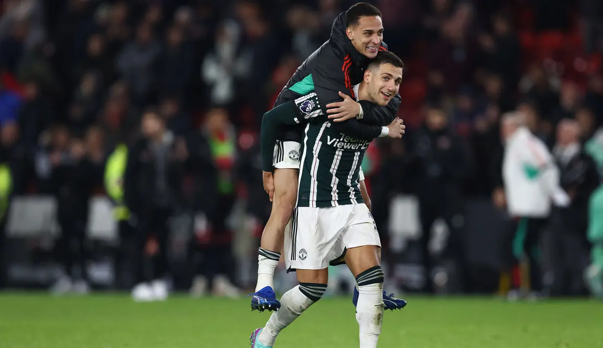 Bek Manchester United, Digo Dalot bersama rekannya, Antony merayakan kemenangan 2-1 timnya atas Sheffield United setelah berakhirnya laga pekan ke-9 Liga Inggris 2023/2024 di Bramall Lane, Sheffield, Minggu (22/10/2023) dini hari WIB. (AFP/Darren Staples)