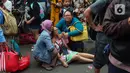 Warga mencoba menenangkan korban kebakaran di kawasan padat penduduk di Jalan Simprug Golf II RT 4/8, Grogol Selatan, Kebayoran Lama, Jakarta Selatan, Minggu (21/8/2022). Hingga siang ini, petugas pemadam kebakaran bersama warga masih terus berusaha untuk memadamkan api. (Liputan6.com/Angga Yuniar)