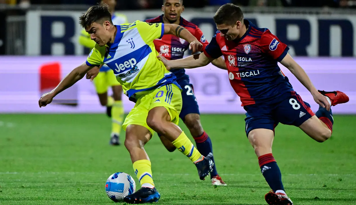 Penyerang Juventus, Paulo Dybala (kiri) mengontrol bola dari kawalan pemain Cagliari, Razvan Marin pada pertandingan lanjutan Liga Serie A Italia di Stadion Unipol Domus, Cagliari, Italia, Minggu (10/4/2022). Juventus menang atas Cagliari 2-1. (AFP/Alberto Pizzoli)