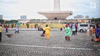 Petugas kebersihan membersihkan sisa sampah usai perayaan Tahun Baru 2019 di Monas, Jakarta, Selasa (1/1). Total sampah di DKI Jakarta saat perayaan Tahun Baru 2019 berkurang dari tahun lalu. (Liputan6.com/Faizal Fanani)