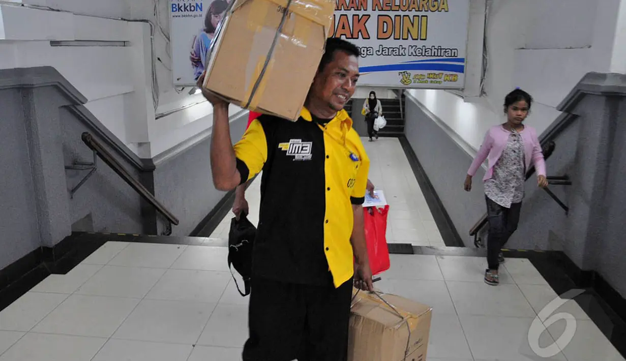 Seorang kuli panggul di Stasiun Pasar Senen terlihat mengangkut barang bawaan pemudik, Jakarta, Jumat (1/8/14). (Liputan6.com/Faizal Fanani)