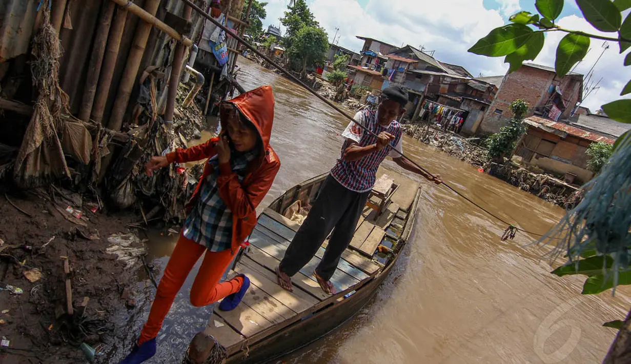 Seorang warga terlihat turun dari perahu eretan yang terbuat dari kayu. (Liputan6.com/Faizal Fanani)