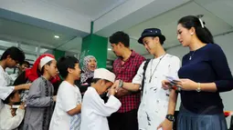 Sejumlah pemain dari ABG Jadi Manten memberikan santunan kepada anak yatim di Rumah Susun Petamburan, Jakarta, Selasa (5/8/14). (Liputan6.com/Andrian M Tunay)