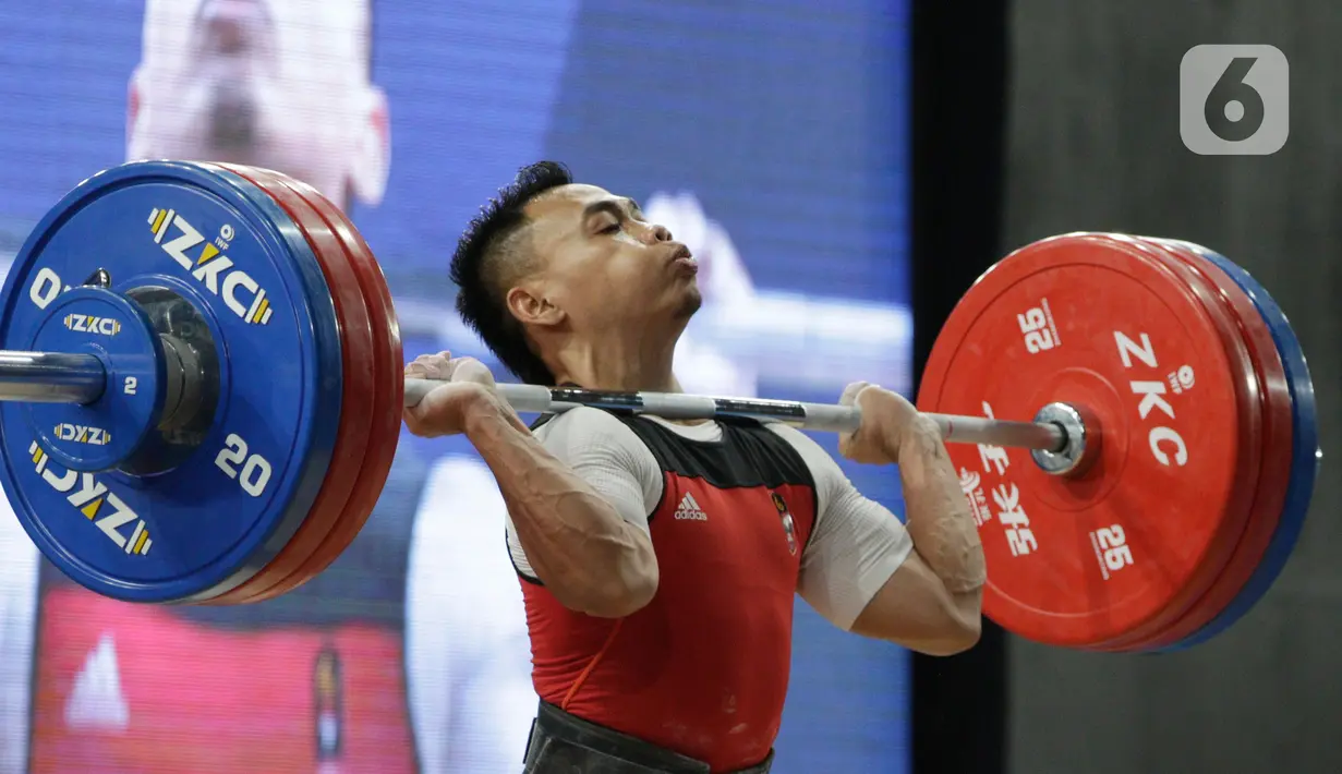 Lifter Eko Yuli melakukan angkatan saat SEA Games 2019 cabang angkat besi nomor 61 kg di Stadion Rizal Memorial, Manila, Filipina, Minggu (1/12/2019). Dirinya meraih emas dengan total angkatan 309 kg. (Bola.com/M Iqbal Ichsan)