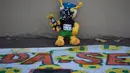 Sebuah boneka Fuleco Armadillo (maskot resmi Piala Dunia 2014) dihias menyerupai demonstran yang melakukan aksi unjuk rasa di Rio de Janeiro, Brasil, (15/6/2014). (REUTERS/Marco Bello)