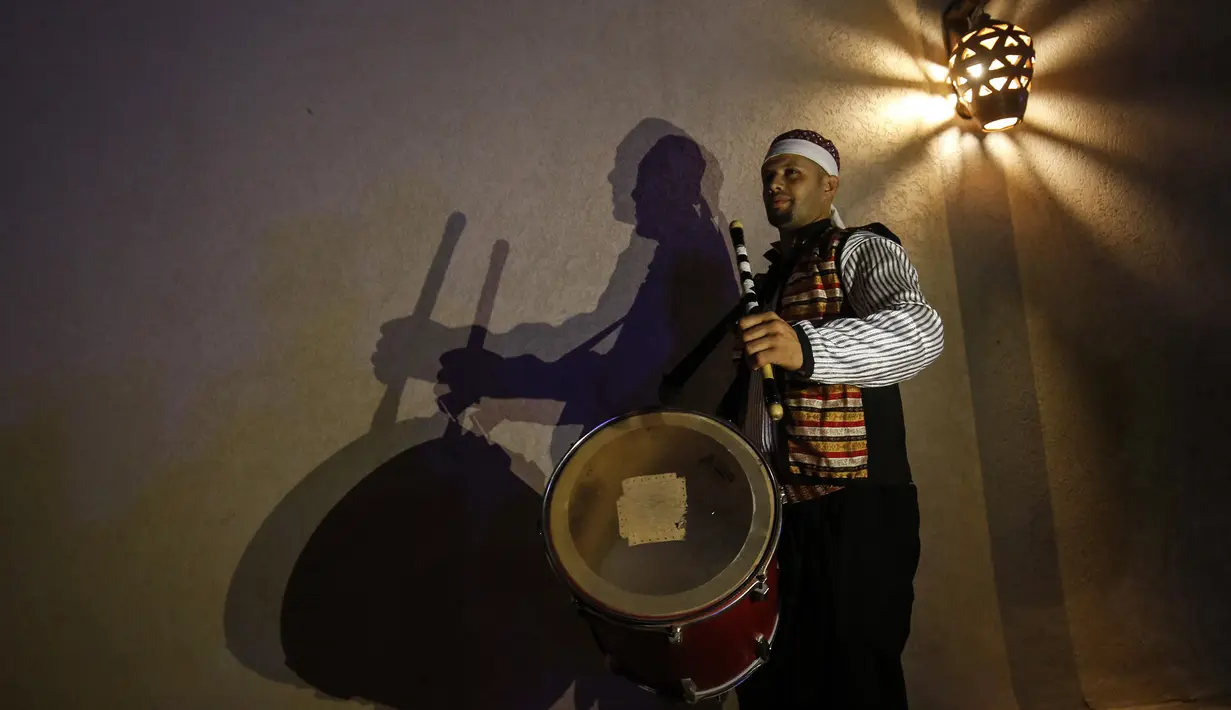 Seorang "Musharati" Palestina memainkan gendang saat membangunkan umat muslim untuk sahur pada malam kedua selama bulan suci Ramadan di Rafah di Jalur Gaza selatan (25/4/2020). (AFP/Said Khatib)