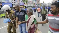 Seorang wanita tua dibantu menyelamatkan diri pasca-ledakan di St. Anthony, Sri Lanka ( Eranga Jayawardena / AP )