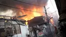 Warga berusaha memadamkan api pada kebakaran di Kompleks Bearland, Kelurahan Kebon Manggis, Matraman, Jakarta, (14/10/14). (Liputan6.com/Faizal Fanani)