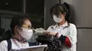 Siswa yang mengenakan masker memeriksa kertas di luar sekolah sebelum hari pertama ujian masuk perguruan tinggi nasional China, atau dikenal gaokao, di Beijing, Selasa (7/6/2022). Lebih dari 11 juta siswa sekolah menengah di seluruh China akan mengikuti ujian masuk perguruan tinggi tahunan setelah negara itu baru saja mengatasi wabah COVID-19 yang parah di Shanghai dan Beijing (AP Photo/Andy Wong)