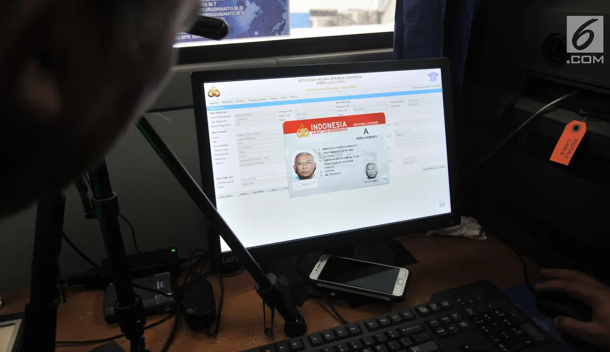 Petugas menunjukkan hasil Smart SIM (Surat Izin Mengemudi) sebelum dicetak saat proses pembuatan di Jakarta, Minggu (22/9/2019). Proses pembuatan Smart SIM tidak mengunakan pemindaian mata, melainkan sidik jari yang telah tersinkronisasi dengan data kepolisian. (merdeka.com/Iqbal S Nugroho)