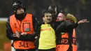 Pihak keamanan menangkap seorang suporter yang masuk ke lapangan dalam laga leg kedua play-off babak Liga Europa 2022/2023 antara Nantes melawan Juventus yang berlangsung di Stade de la Beaujoire, Jumat (24/2/2023). (AFP/Sebastien Salom-Gomis)