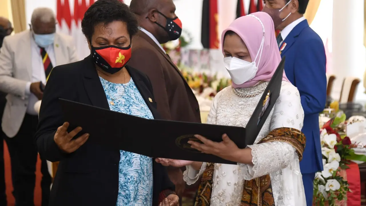 Ibu Negara Iriana Jokowi memberikan kenang-kenangan berupa selendang sutra untuk istri PM Papua Nugini, Rachel Marape.