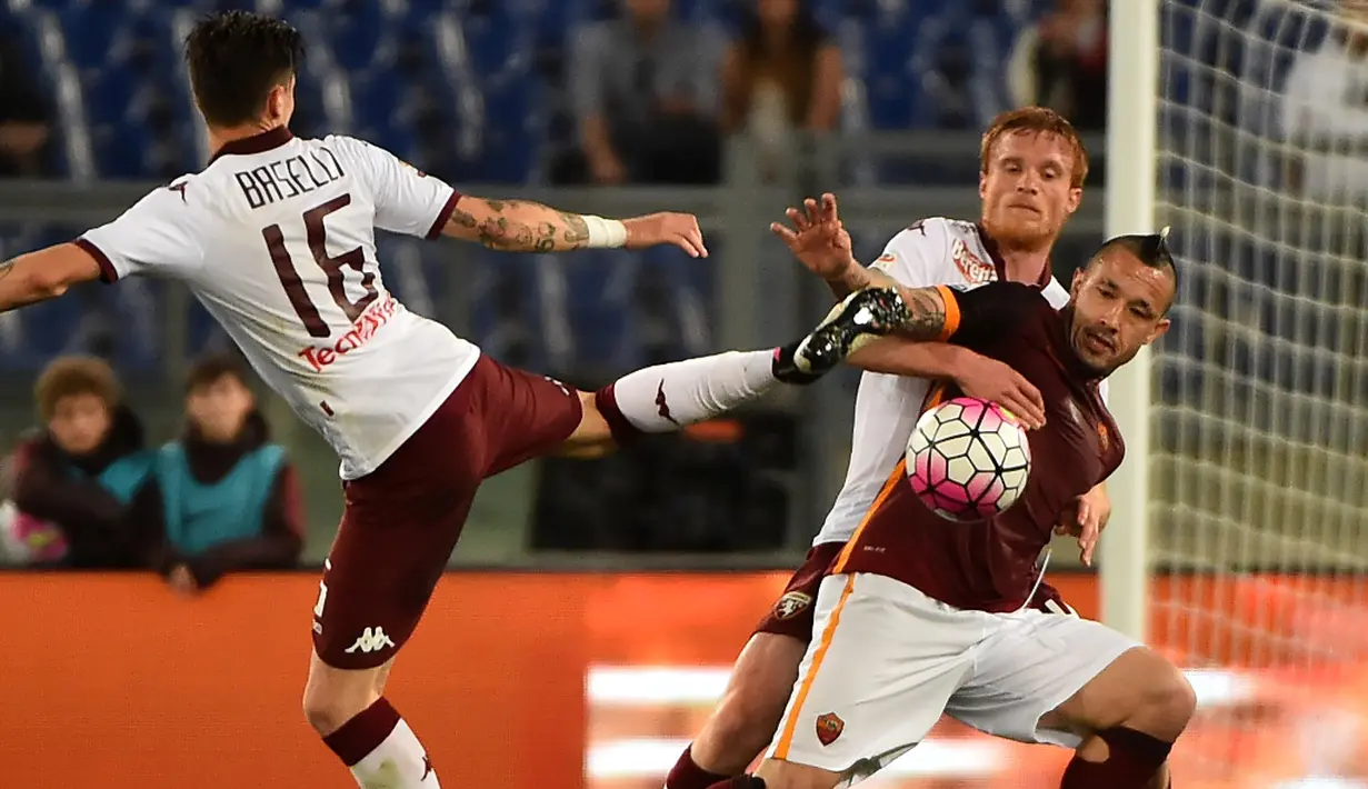 Pemain AS Roma, Radja Nainggolan, berebut bola dengan dua pemain Torino pada pertandingan Serie A di Stadion Olimpico, Roma, Kamis (21/4/2016) dini hari WIB. (AFP/Gabriel Bouys)