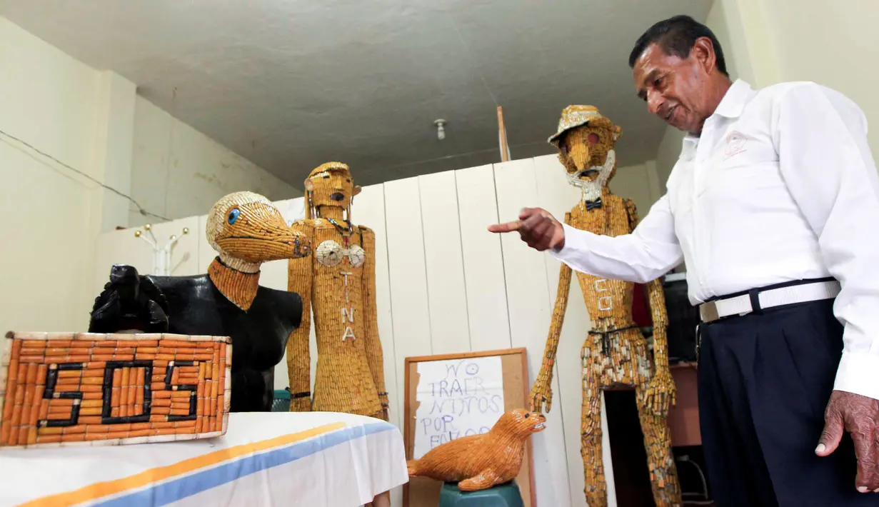 Miguel Andagana menunjukkan boneka yang terbuat dari puntung rokok di rumahnya Puerto Ayora, di Kepulauan Galapagos (9/10). Andagana ingin diakui oleh Guinness Records sebagai orang yang memberantas puntung rokok. (REUTERS/Guillermo Granja)