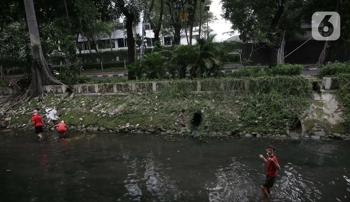Sejumlah anak-anak mencari belut di anak kali menteng, Jakarta, Selasa (8/6/2021). Ruang bermain anak-anak di Jakarta kian terbatas. Terbatas lahan bermain membuat anak-anak Jakarta bermain ditempat yang tak semestinya demi mencari kesenangan. (Liputan6.com/Faizal Fanani)