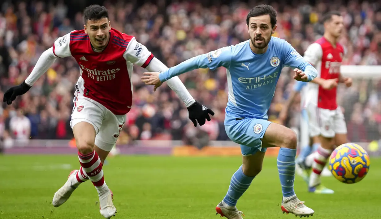 Pemain Arsenal Gabriel Martinelli (kiri) menantang pemain Manchester City Bernardo Silva pada pertandingan sepak bola Liga Inggris di Stadion Emirates, London, Inggris, 1 Januari 2022. Manchester City menang 2-1. (AP Photo/Matt Dunham)