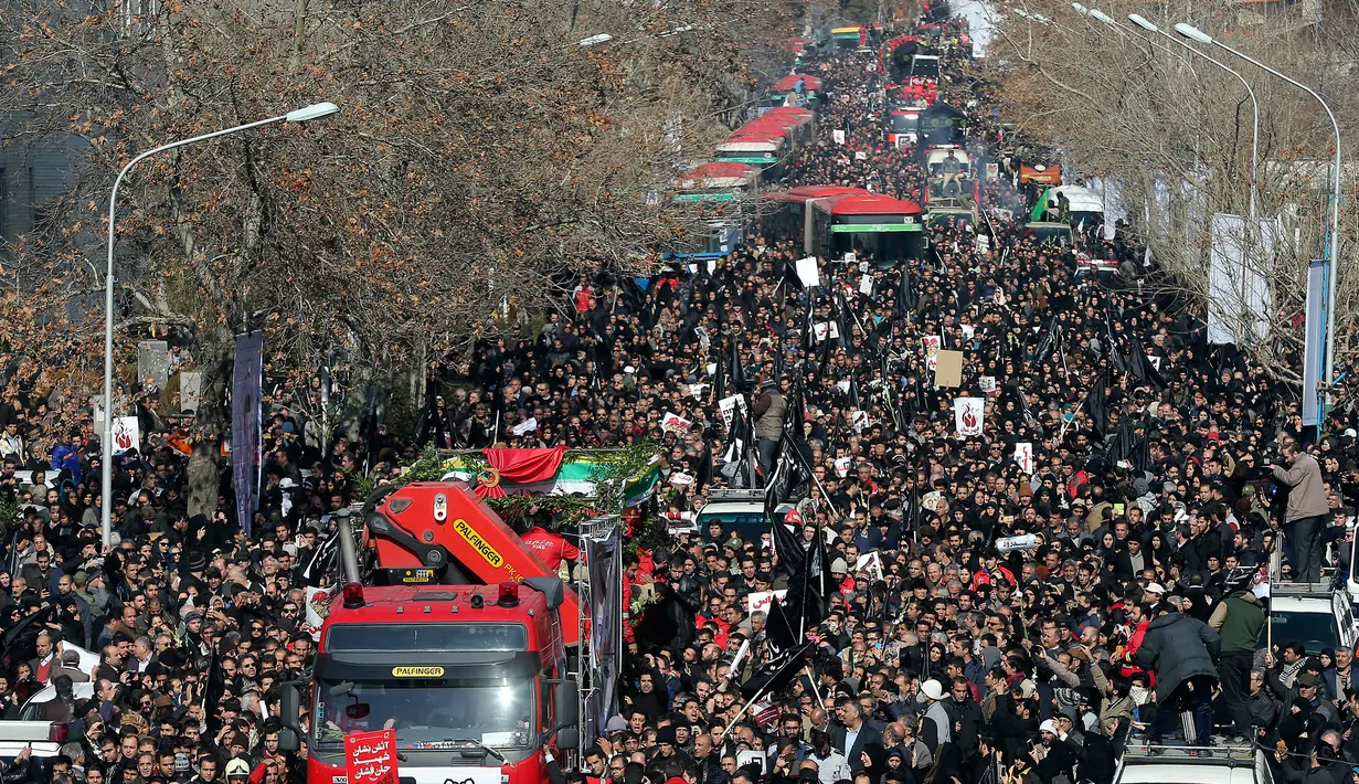Warga Iran mengiringi jenazah 16 petugas pemadam kebakaran yang tewas dalam runtuhnya gedung yang terbakar pada 19 Januari, di Teheran, Iran, Senin (30/1). (AP Photo / Ebrahim Noroozi)