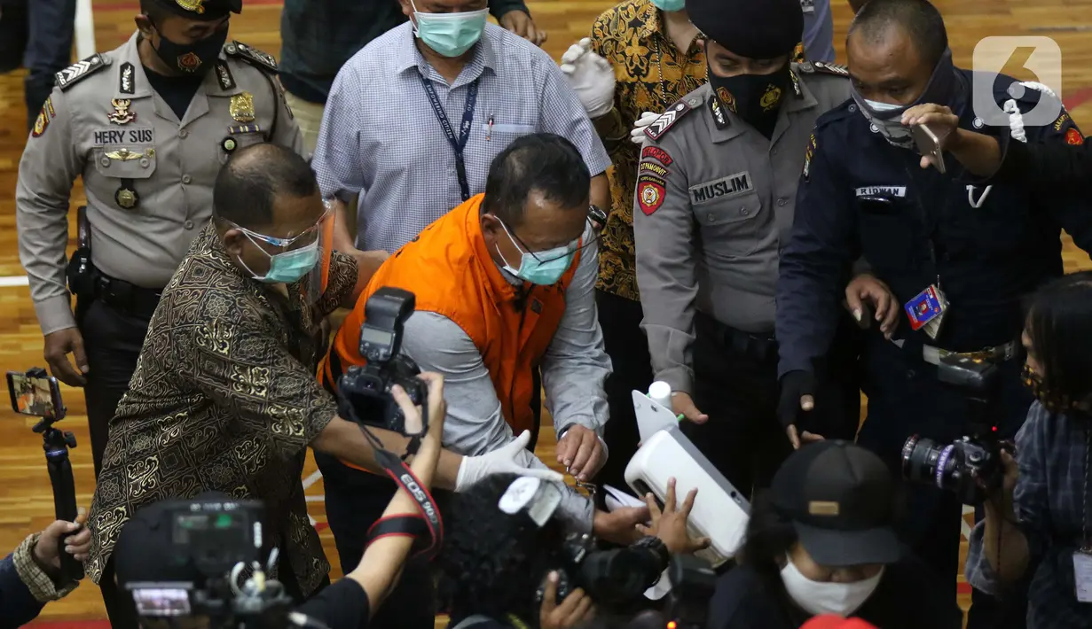 Menteri Kelautan dan Perikanan, Edhy Prabowo (tengah) digiring petugas usai rilis penetapan tersangka kasus dugaan suap penetapan calon eksportir benih lobster di Gedung KPK Jakarta, Kamis (26/11/2020). Sebelumnya, Edhy ditangkap KPK usai lawatan ke Amerika. (Liputan6.com/Helmi Fithriansyah)