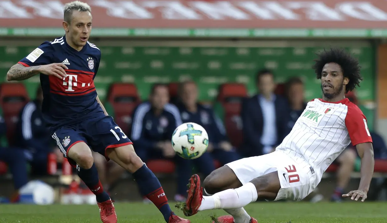 Bek Bayern Munchen, Rafinha, berebut bola dengan penyerang FC Augsburg, Caiuby, pada laga Bundesliga di WWK Arena, Augsburg, Sabtu (7/4/2018). Bayern Munchen menang 4-1 atas FC Augsburg. (AP/Matthias Schrader)