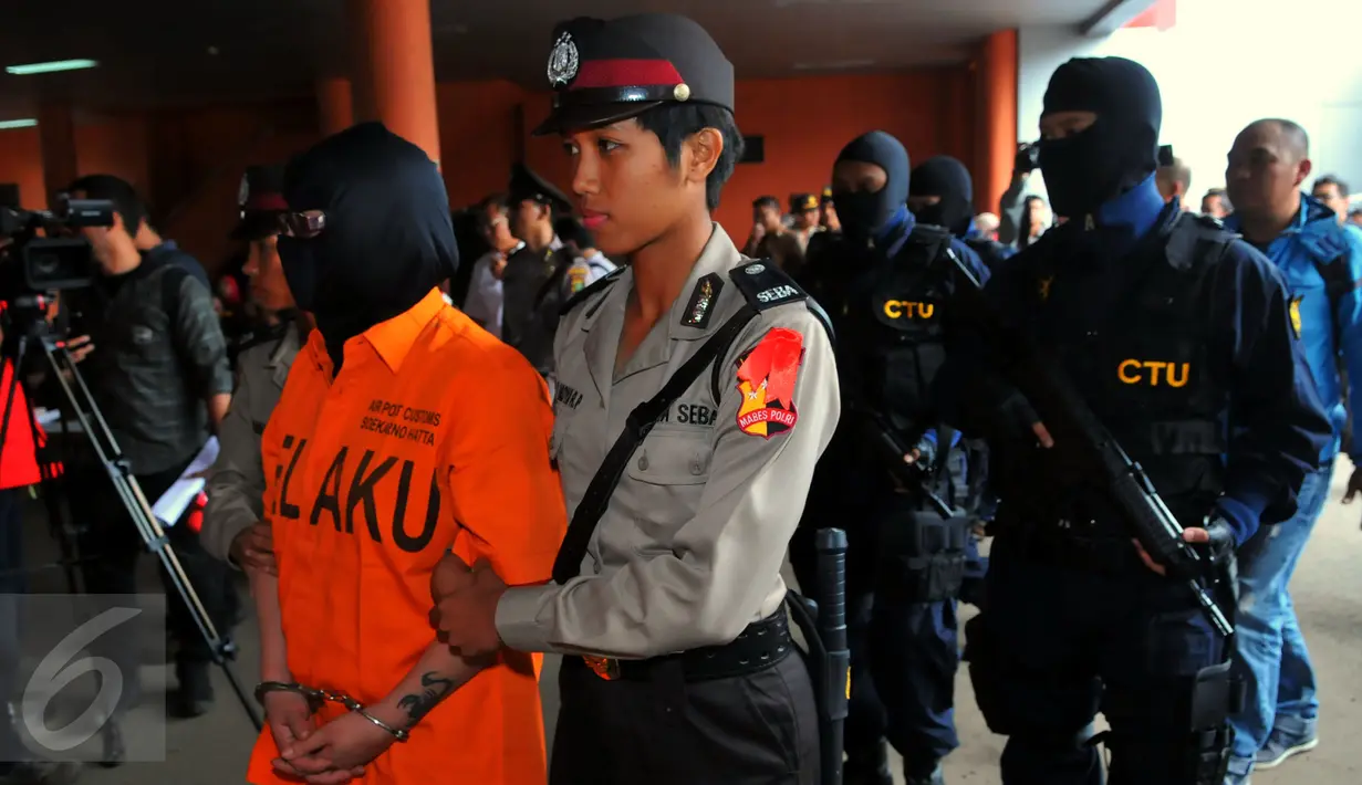 Petugas kepolisan saat menggelandang para pelaku pelanggar ekspor dan impor barang - barang ilegal di Bandara Soekarno Hatta, Tangerang, (16/2). (Liputan6.com/Faisal R Syam)