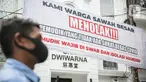 Seorang pria melintas di dekat spanduk peringatan untuk pemudik di kawasan Kartini, Sawah Besar, Jakarta, Senin (17/5/2021). Spanduk tersebut untuk memperingati warga yang kembali dari mudik lebaran agar membawa surat bebas COVID-19. (Liputan6.com/Faizal Fanani)