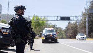 Petugas polisi melakukan pemeriksaan keamanan di Jalan Raya Morelia-Patzcuaro untuk mencegah pembakaran kendaraan dan blokade jalan di negara bagian Michoacan, Meksiko, pada 23 Februari 2026. (Enrique Castro/AFP)