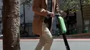 Seorang pria bernama Jack Handlery mengendarai skuter bermotor di jalanan di San Francisco (17/4). San Francisco menghentikan operasi perusahaan yang menyewakan skuter bermotor. (AP/Jeff Chiu)