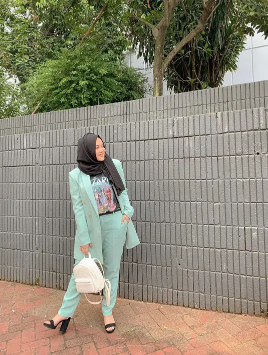 Tak cuma gaya santai, Putri Delina juga bagikan outfit semi-formal. Setelan blazer dan celana kain warna tosca jadi pilihannya. Ditambah jilbab hitam, tas putih dan sepatu hak tinggi, penampilannya bak wanita karir. (Liputan6.com/IG/@putridelinaa)
