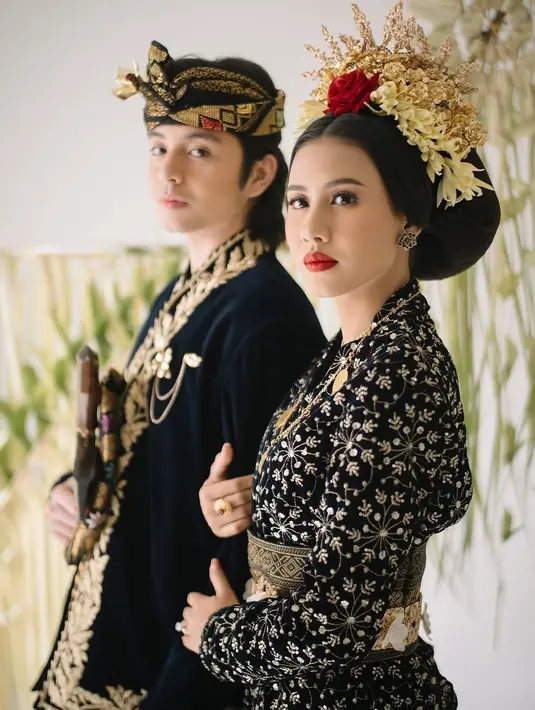 Sementara itu, Shenina memancarkan keanggunan dengan kebaya beludru hitam bersulam benang emas, dipadukan dengan kain songket dan perhiasan emas. Hiasan kepala bunga emas dan mawar melengkapi tampilannya yang elegan. [@angga].