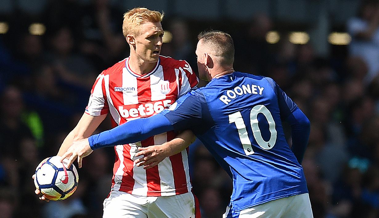 Wayne Rooney (kanan) mencoba merebut bola dari pemain Stoke City, Darren Fletcher pada laga perdana Premier League 2017-2018 di Goodison Park, Liverpool (12/8/2017). Everton menang 1-0. (AFP/Oli Scarff)