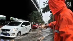 Petugas PPSU mengatur lajur kendaraan saat banjir menggenangi Jalan DI Panjaitan, Jakarta, Senin (3/12). Hujan deras yang mengguyur Jakarta sejak siang tadi menyebabkan banjir menggenangi hingga sebetis orang dewasa. (Merdeka.com/ Iqbal S. Nugroho)