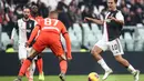 Striker Juventus, Paulo Dybala, berusaha melewati bek Udinese, Sebastien De Maio, pada laga Serie A di Stadion Allianz, Turin, Minggu (15/12). Juventus menang 3-1 atas Udinese. (AFP/Isabella Bonotto)