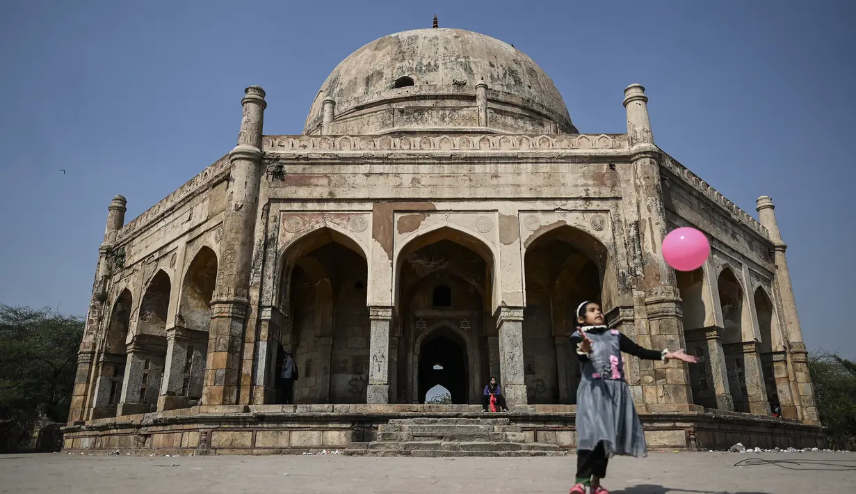 Seorang gadis muda bermain dengan balon saat dia mengunjungi Makam Adham Khan abad ke-16, juga dikenal sebagai (Bhool Bhulaiya), di New Delhi (16/2/2022). Dia adalah putra bungsu Maham Anga, perawat Akbar yang basah, dan juga saudara angkatnya. (AFP/Sajjad Hussain)