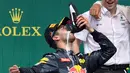 Ekspresi pembalap Red Bull Daniel Ricciardo ketika meminum sampanye dengan menggunakan sepatunya di atas podium pada selebrasi kemenangan selama Grand Prix Formula 1 Jerman, Minggu (31/7). Pembalap asal Australia itu menjadi juara dua (THOMAS KIENZLE/AFP)