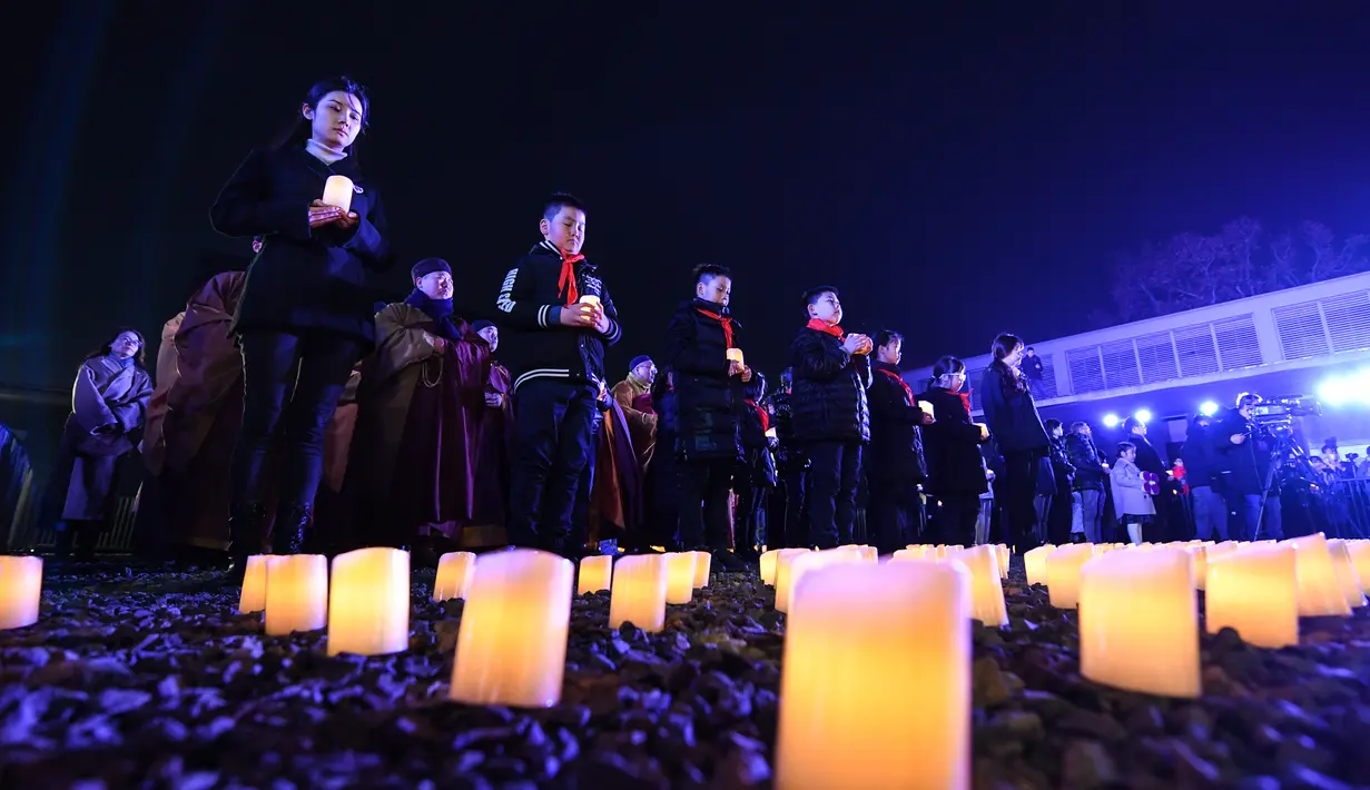 Sejumlah orang ambil bagian dalam acara penyalaan lilin untuk mengenang para korban Pembantaian Nanjing di hari peringatan nasional ketujuh di Balai Peringatan Korban Pembantaian Nanjing oleh Tentara Jepang di Nanjing, ibu kota Provinsi Jiangsu, China timur, pada 13 Desember 2020. (Xinhua/Li Bo)