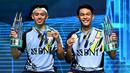 Ganda putra Indonesia Fajar Alfian (kanan) dan Muhammad Rian Ardianto memegang medali dan piala setelah keluar sebagai juara dalam final Malaysia Open 2023 di Axiata Arena, Kuala Lumpur, Minggu (15/1/2023). Tak hanya berhasil meraih gelar pertama turnamen level Super 1000, Fajar/Rian juga untuk kali pertama menjadi juara dengan predikat sebagai nomor satu dunia. (AFP/Mohd Rasfan)