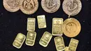 Sebelumnya, harga emas Antam dipatok Rp 2.652.000 per gram. Tampak dalam foto, koin dan batangan emas dipajang di sebuah toko perhiasan di Banda Aceh pada Rabu 14 Januari 2026. (CHAIDEER MAHYUDDIN/AFP)
