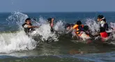 Migran berusaha menaiki perahu milik penyelundup dari pantai Equihen-Plage, Prancis utara, Rabu (23/9/2026), untuk menyeberangi Selat Inggris menuju Inggris. (Sameer Al-DOUMY/AFP)
