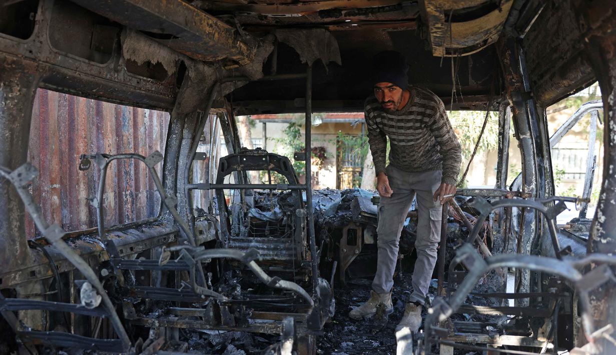 Diketahui, Israel telah menduduki Tepi Barat sejak 1967. Tampak dalam foto, seorang pria Palestina memeriksa kendaraan yang rusak akibat serangan oleh pemukim Israel di desa Jabaa dekat Bethlehem, di Tepi Barat yang diduduki, pada Selasa 18 November 2025. (AHMAD GHARABLI/AFP)