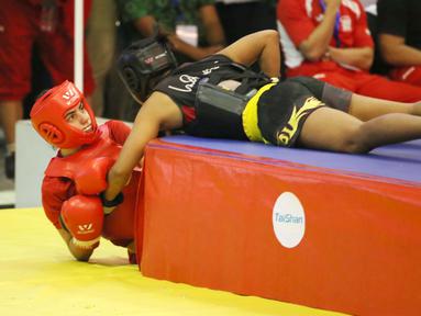 Atlet wushu Indonesia, Moria Manalu (kanan), membanting lawannya asal Turki, Nagihan Kalyoncu, di kelas Sanda Wanita 60 kg pada Kejuaraan Dunia Wushu 2015 di Istora Gelora Bung Karno, Senayan, Jakarta, Senin (16/11/2015). (Bola.com/Nicklas Hanoatubun)