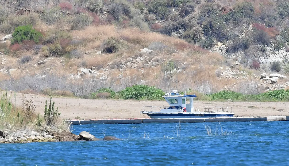 Sebuah kapal sheriff Ventura County terlihat di dekat teluk kecil di Danau Piru, California, Senin (13/7/2020). Jasad aktris Glee Naya Rivera yang dinyatakan menghilang pada 8 Juni 2020 lalu telah ditemukan tewas di Danau Piru pada Senin (13/7). (Frederic J. BROWN / AFP)