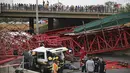 Warga mengamati paramedis yang mengevakuasi korban setelah perancah atau scaffolding sebuah jembatan yang sedang dibangun ambruk di jalan tol M1 menuju Sandton, Afrika Selatan, Rabu (14/10). Kejadian tersebut menewaskan dua orang. (REUTERS/Siphiwe Sibeko)