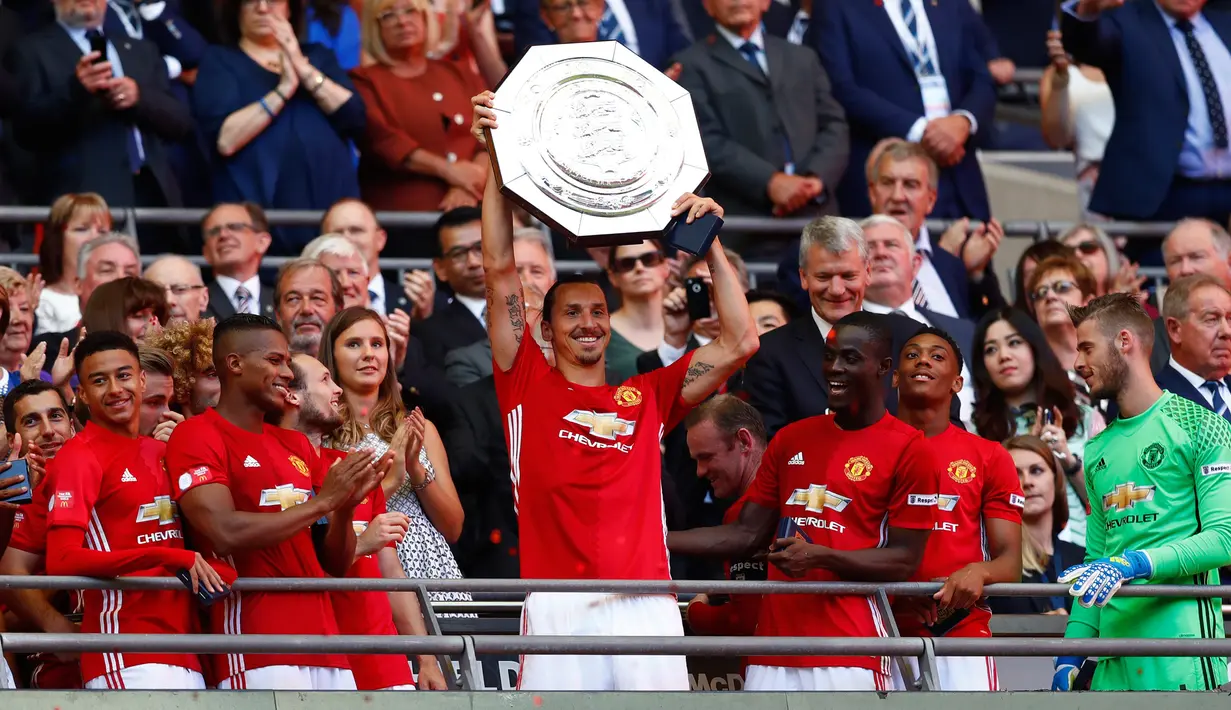 Penyerang MU, Zlatan Ibrahimovic mengangkat trofi bersama rekan-rekannya usai menjuarai Piala Community Shield di stadion Wembley, London, Inggris, (1/8). MU juara usai mengalahkan Leicester City dengan skor akhir 2-1. (Reuters/Eddie Keogh)
