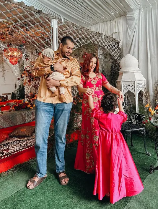 Tasya Farasya dan keluarga kecilnya juga tak mengenakan baju Lebaran berwarna sage. Tasya Farasya tampil cantik dengan baju bak pengantin India berwarna merah dengan bordiran berwarna emas yang cantik, seragam dengan putri pertamanya. Sedangkan suami dan anak keduanya tampil seragam dengan atasan kemeja lengan panjang bernuansa emas dan celana panjang. Foto: Instagram.