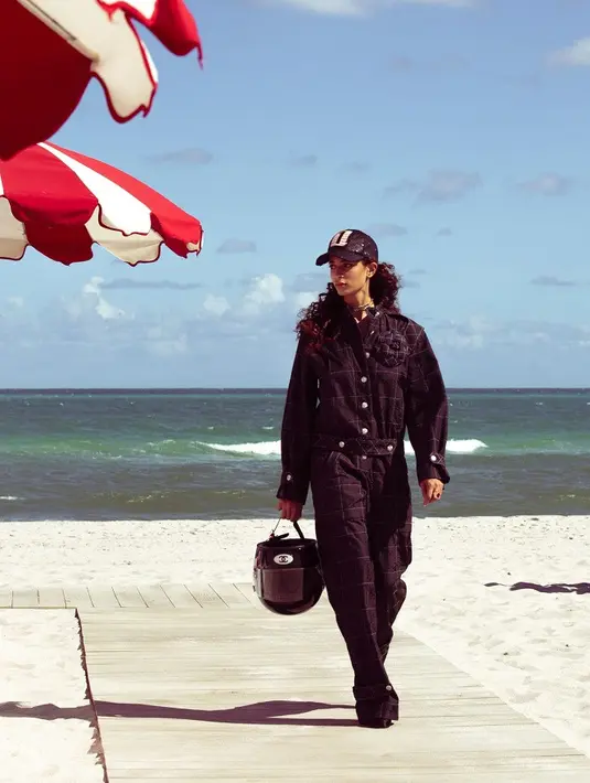 Mulai dari baju kru pit, tas berbentuk helm, setelan blazer, gaun motif kotak-kotak, hingga jumpsuit dengan latar sirkuit balap. [Dok/Chanel].